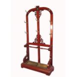 A 19th century mahogany coat stand, of arched design with fret cut spandrels, with fitted umbrella