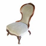 A Victorian spoon backed grandmother's chair, with carved floral decoration, raised on front