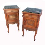 A pair of continental bedside cabinets, with black veined marble top, panelled doors and raised on