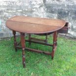 An antique oak gateleg dining table, fitted with a drawer to one end, raised on turned legs, 38ins x