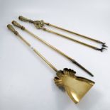 A set of three brass fire irons comprising poker, shovel and tongs with chased Adams style finials