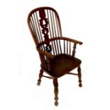 A 19th century Windsor armchair, having a pierced vase splat, the legs united by a crinoline