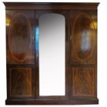 A mahogany triple door wardrobe, with a central bevelled plate mirror, having cross banded