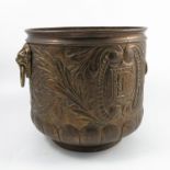 A brass coal or log bucket, with lion mask and ring handles, the body with embossed decoration of