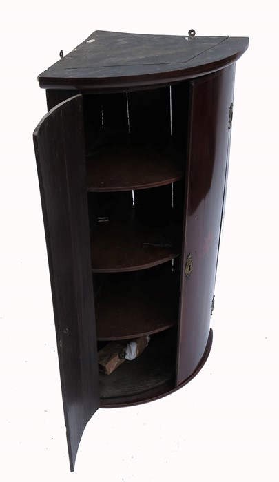 A late Georgian mahogany small bow front corner cabinet, the doors with star decoration, maximum