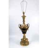 A gilt metal table lamp, of urn shaped support, raised on a reeded turned pedestal, height 24.5ins