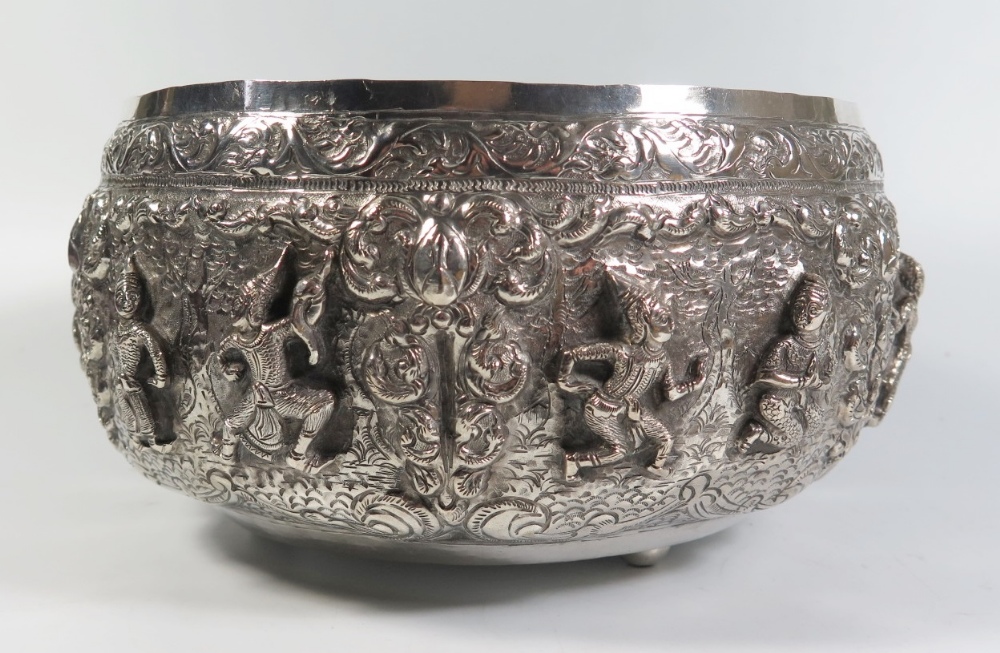 A Large Asian Silver Bowl with repoussé decorated scenes of dancers, engraved mark to base, 892g, 25