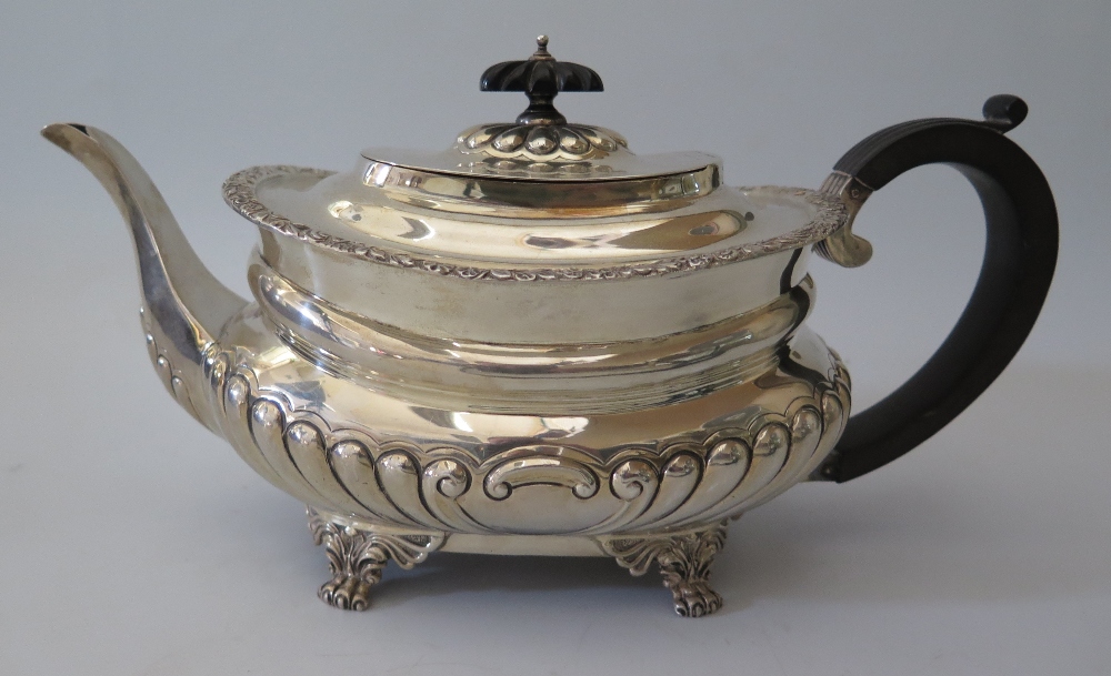 A George V Silver Teapot standing on lion paw feet with gadrooned waist and foliate border, London