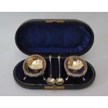 A Pair of Victorian Cased Silver and Gilt Lined Salts with matching spoons with scrolling foliate