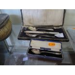 A Cased Silver Christening Flatware Set and one other cased spoon