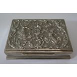 An Asian Silver Cigarette Box decorated with dancers and stylised foliate work