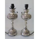 A Pair of Continental Sterling Silver Lamp Bases with foliate scroll and rose decoration comma