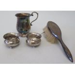 A silver christening mug, pair of silver salts with spoons and silver backed hair brush