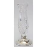A cut crystal vase with loaded silver base