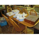 An Ercol Light Elm Dining Table and ten chairs including two carvers