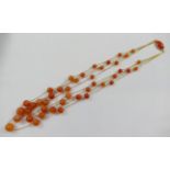 A carnelian and yellow metal four strand necklace,