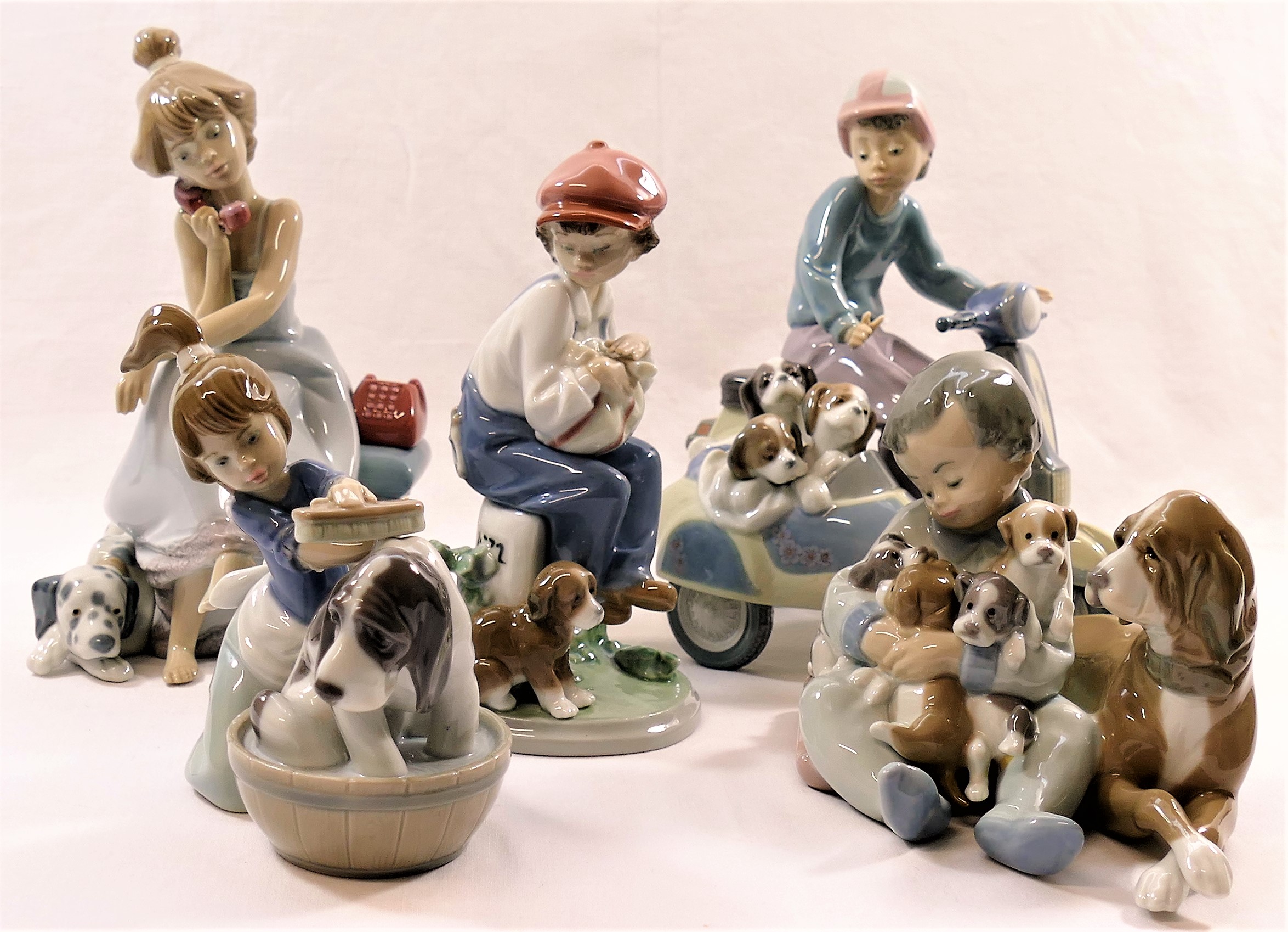Five Lladro figural groups with dogs and puppies, the tallest 19.