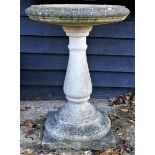 A reconstituted stone bird bath, of plain form on square plinth, 53cm diameter x 73.