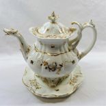 A Victorian Coalport Rococo style teapot and stand, with gilt decoration and lilac detail,