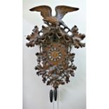A large 19th century ornate Black Forest cuckoo clock, decorated with an eagle surmount,