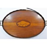 An Edwardian oval mahogany serving tray, with inlaid shell patera, brass handles and wavy rim, 68.