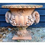 A pair of terracotta ornate garden urns, cast with rams head masks and oak leaves with acorns,