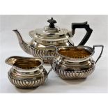 A silver three piece teaset, with half gadrooned body, Sheffield 1906,
