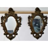 A pair of Rococo style cartouche-shaped wall mirrors, with pierced and carved gilt frames,