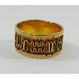 A yellow metal band with raised and decorated sides, the centre decorated with wire symbols,