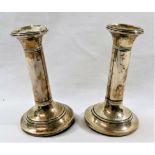 A pair of silver candlesticks, Birmingham 1908, with loaded circular bases and turned stems, 14.