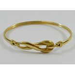 A yellow gold bangle, with stylised twist decoration and part matt finish, stamped '750', 9.