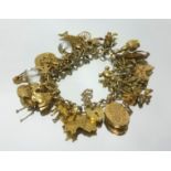 A 9ct gold charm bracelet with padlock clasp and safety chain, consisting of thirty two 9ct gold