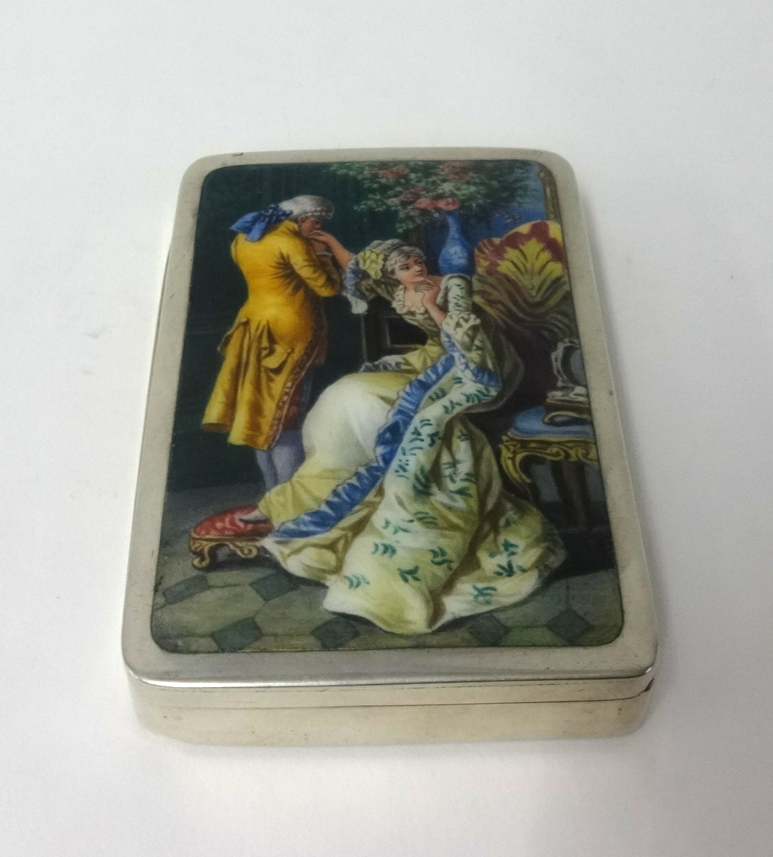 An enamelled box (no hallmark), approx 9.50cm x 6.50cm, decorated with classical romantic scene of a