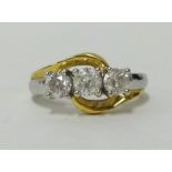 A three stone diamond ring set in white and yellow gold, finger size P.