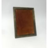 A silver rectangular photo frame, approx 24cm x 19cm with a wood easel back, indistinct hallmark.