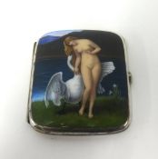 An enamel cigarette case, decorated with nude lady and swan in a landscape, gilt lined, approx 9.