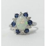 An 18ct white gold cluster ring set with central opal and within a cluster of sapphire and diamonds,