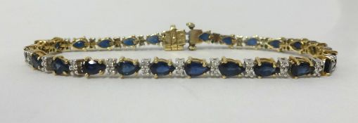 A 9ct gold line bracelet set with sapphire and diamonds, overall length approx 19cm.