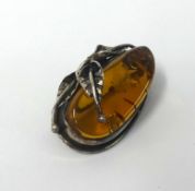 An amber and silver brooch, approx 5cm wide.