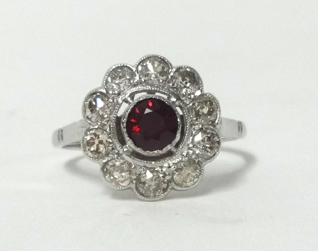 A platinum ruby and diamond cluster ring, finger size M.