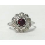 A platinum ruby and diamond cluster ring, finger size M.