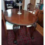 A early 20th Century mahogany extending dining table, the oval top with gadrooned border over carved