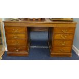 An oak pedestal desk set with an arrangement drawers with brass swan neck handles, width 142cm.