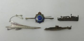 Four badges including silver Concorde, silver submarine, silver battleship and enamelled George V