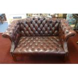 A reproduction leather button back settee.