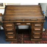 An oak rolled top desk, the tambour front with fitted interior, width 125cm, together with an oak