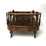 A Victorian figured walnut Canterbury, fitted with lower drawer and pierced fretwork carving on