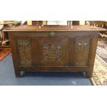 A panelled oak coffer with Art Nouveau style carved front panels.