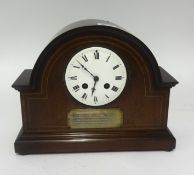 An Edwardian mantel clock in a mahogany inlaid case with presentation plaque to 'D.Hirst'.