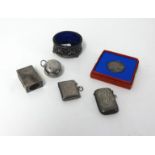 A round silver sovereign holder, two silver vestas, a silver match case, a silver and blue glass
